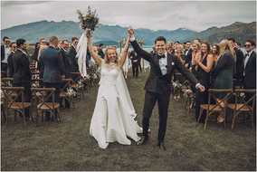 Bride and groom walk down the aisle as newlyweds, smiling with joy while guests cheer — photographed by Karl Lascano in Michigan.