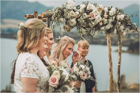 Bridesmaids tear up as they watch the bride approach the altar during a heartfelt outdoor Michigan wedding ceremony.